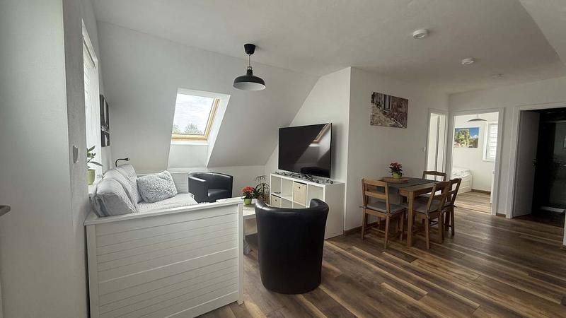 Apartmán 3: pohovka, křesla a jídelní stůl v obývacím pokoji
