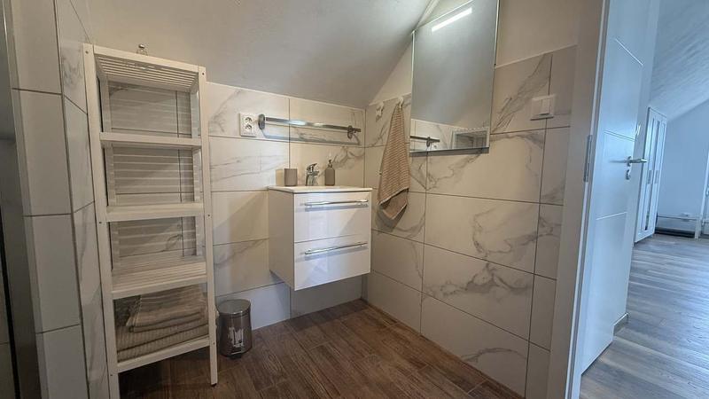 Koupelna apartmánu 3 s mramorovým obkladem a sprchovým koutem